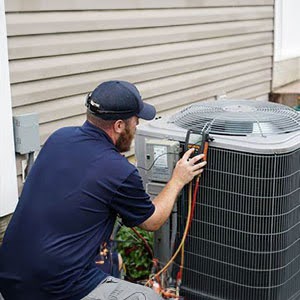 PGA Inc. technician performing maintenance on outdoor AC.