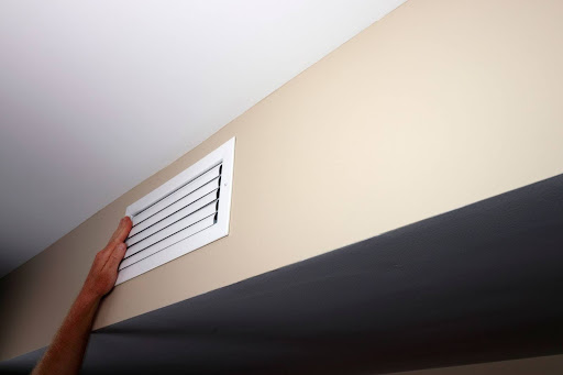 Hand feeling vent to see if it's blowing air.