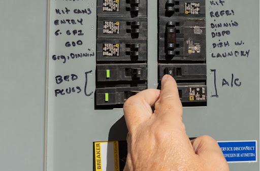Homeowner checking breakers in electrical panel.